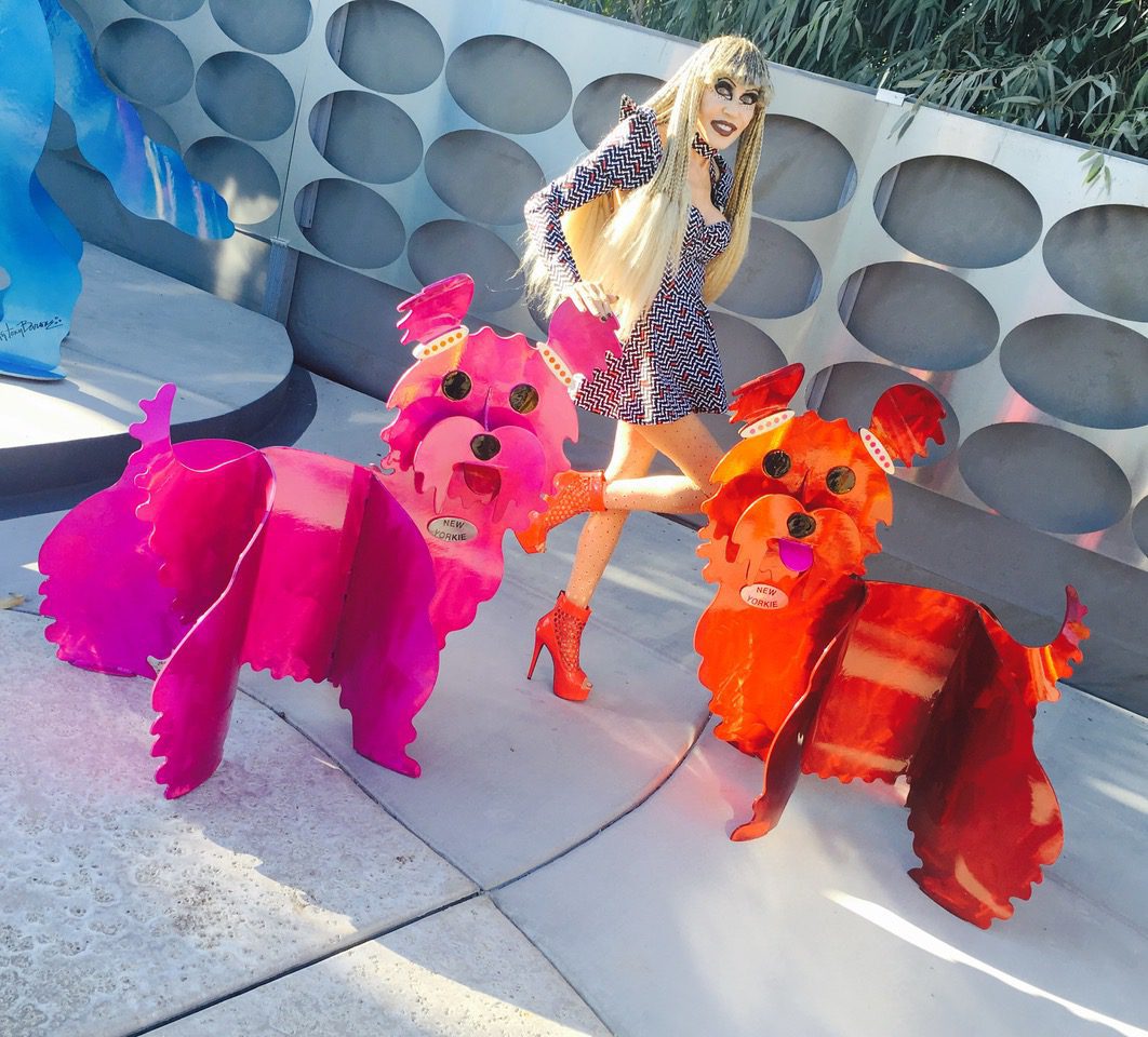 Photo of Karen Barone with New Yorkie Steel Sculptures in pink and orange by Karen and Tony Barone